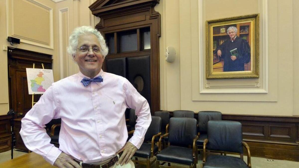 United States District Court Judge Ashley Royal stands in the main courtroom at the Bootle Federal Building Thursday where his likeness was painted recently by a local artist. He will move to senior status soon which means he will handle about 50 fewer cases per year.