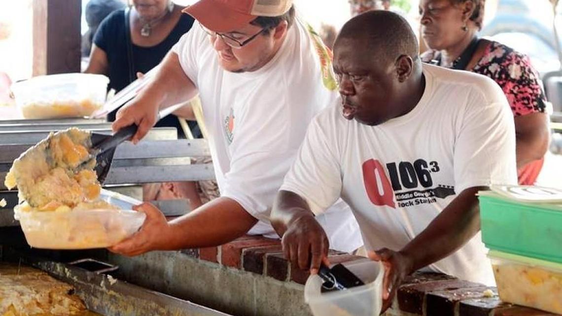 Joshua Fetters, left, and Tony Wilson scoop up portions of the World's Largest Peach Cobbler in this Telegraph file photo during the 2014 Peach Festival in Fort Valley.