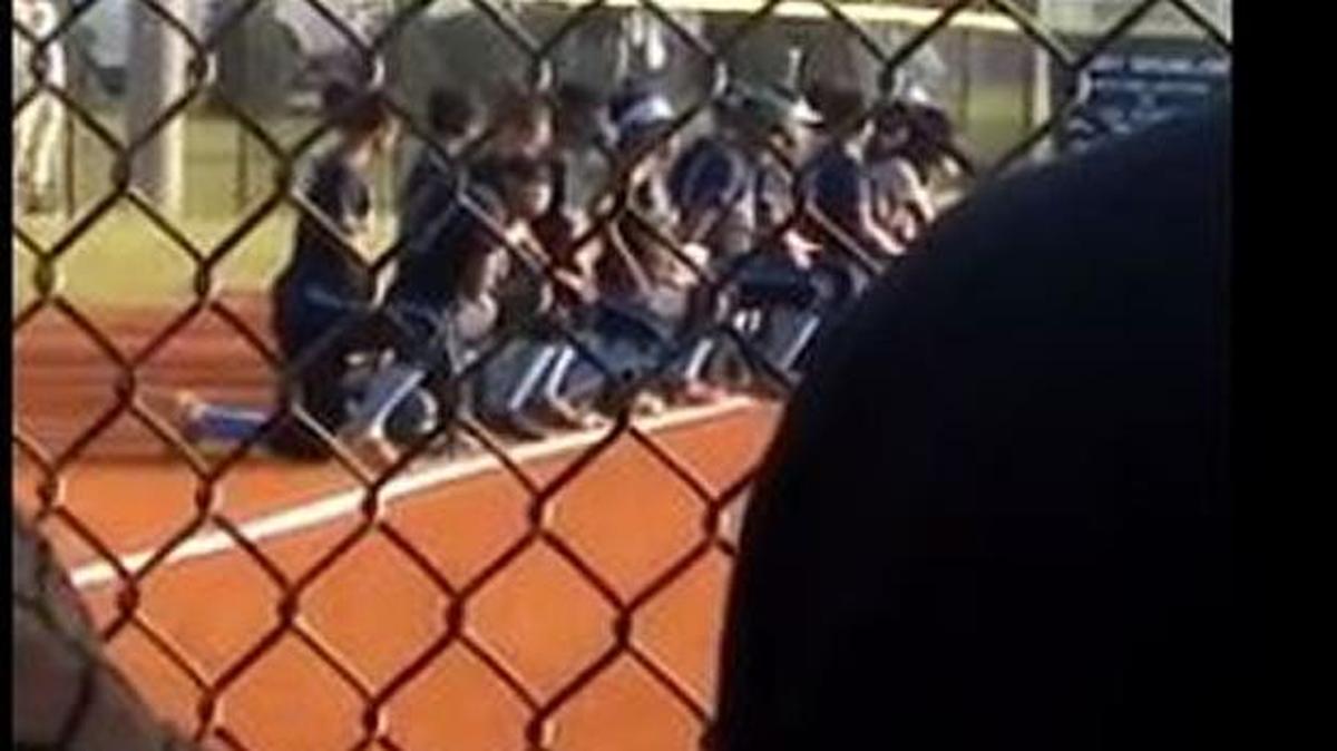 Screen grab of Facebook video showing Cedar Grove softball players kneeling during national anthem prior to state playoff game.