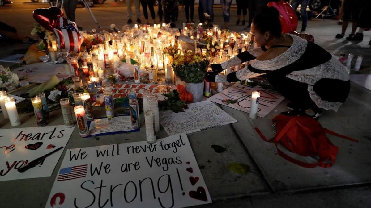 A woman places a candle at a memorial for victims of the mass shooting Tuesday, Oct. 3, 2017, in Las Vegas. A gunman opened fire on an outdoor music concert on Sunday. It was the deadliest mass shooting in modern U.S. history, with dozens killed and hundreds injured, some by gunfire, some during the chaotic escape.
