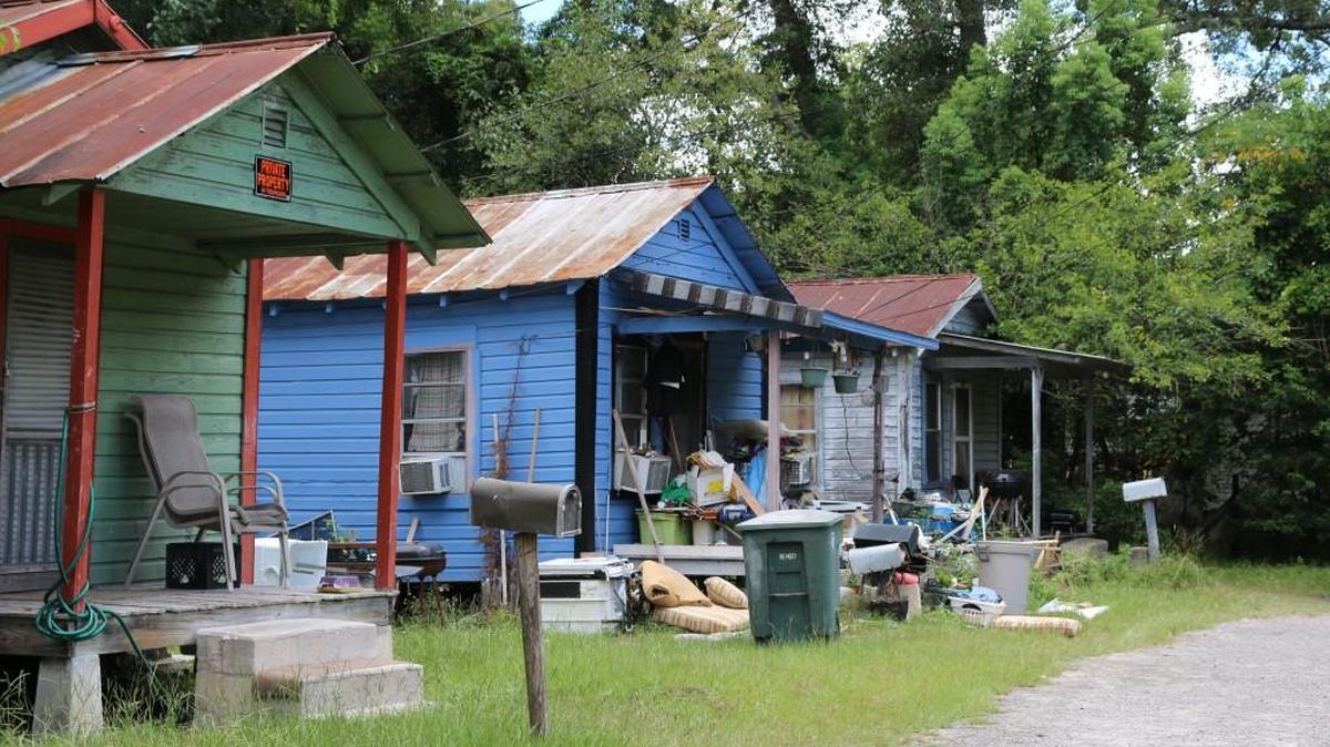 Trash is strewn before a row of shotgun houses on a deep backstreet in Valdosta. While the city has made great strides in alleviating blight, many pockets of decrepit housing remain.