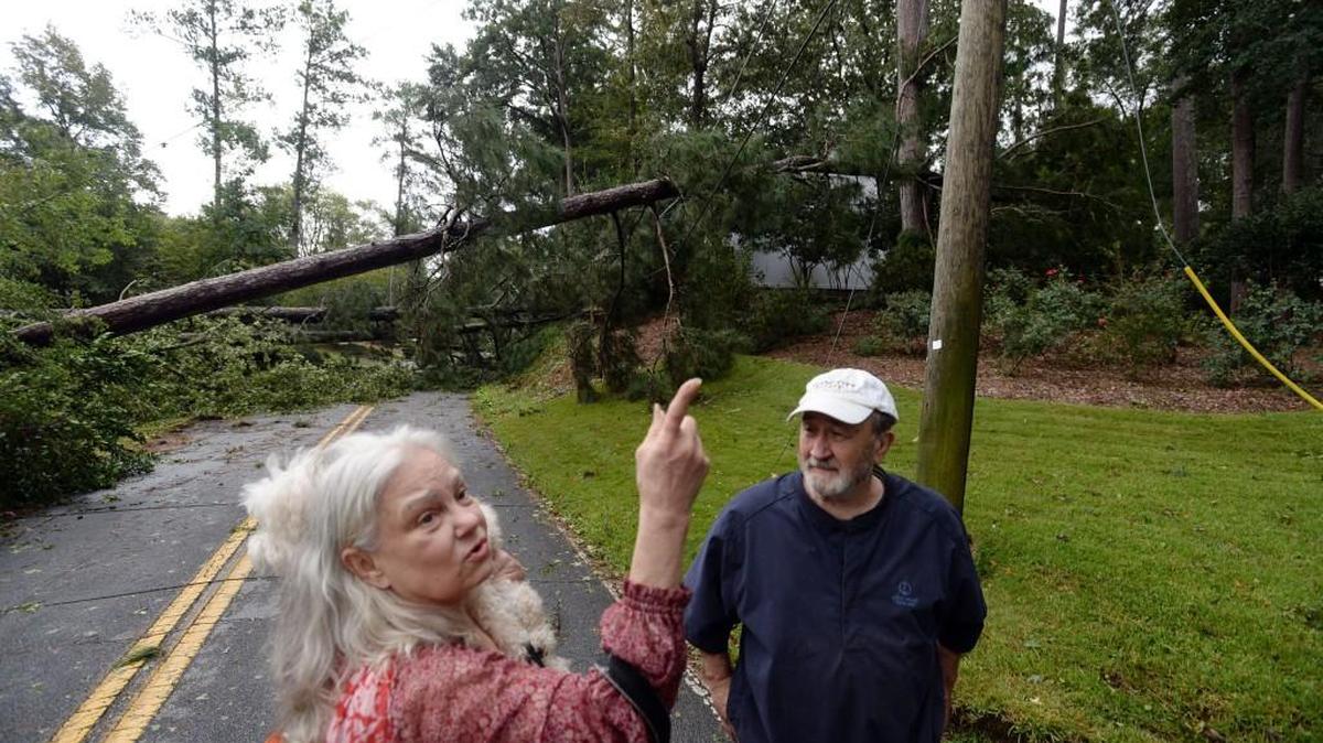 Shirley Hills residents Betty Rivers and Russell Claxton, with downed trees and power lines all around them, look to the skies for more rain and wind after the devastating effects of Tropical Storm Irma.