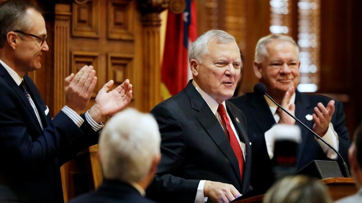 Georgia Gov. Nathan Deal steps to the podium to deliver the State of the State address on the House floor while applauded by Lt. Gov. Casey Cagle, left, and House Speaker David Ralston, right, in Atlanta, Wednesday, Jan. 11, 2017. Deal is asking Georgia lawmakers to support a new plan for fixing low-performing schools after voters last fall rejected a proposal for state takeovers of schools that consistently struggle. The Republican governor said in his State of the State speech Wednesday that nearly 89,000 students were stuck in failing schools last year and their number "will grow with each passing school year" if nothing is done.