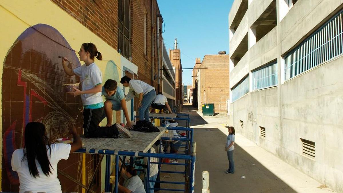 In this file photo, students from Westside High School paint a mural on a wall of Cherry Street Lane in Macon as part of NewTown Macon’s effort to add some beauty to downtown alley ways.