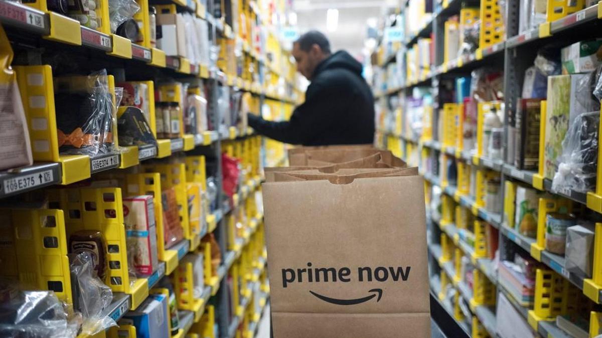 In this Wednesday, Dec. 20, 2017, photo, a clerk reaches to a shelf to pick an item for a customer order at the Amazon Prime warehouse, in New York.