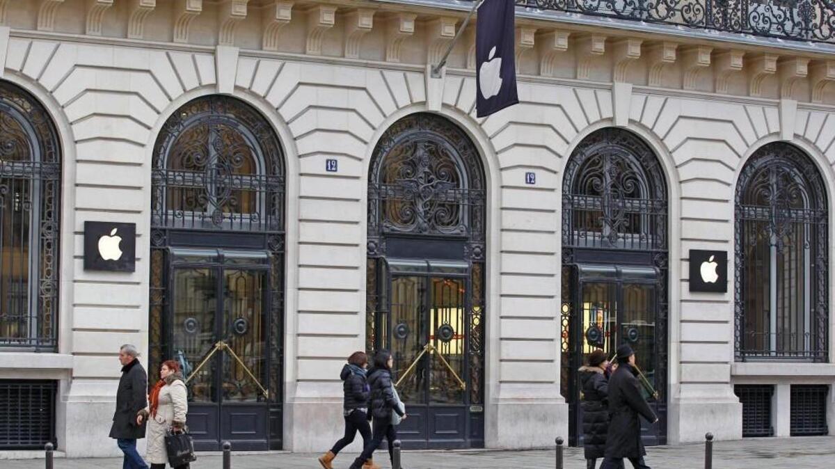 Parisians and tourists wander in front of the Apple store located near the Paris Opera. The House Republican tax bill is meant to send trillions in corporate profits overseas pouring back home and, in the process, give the U.S. economy a healthy boost. Once the bill took effect, most overseas profits could be returned to the United States tax-free. Some very high overseas profits would incur a U.S. tax of 10 percent.