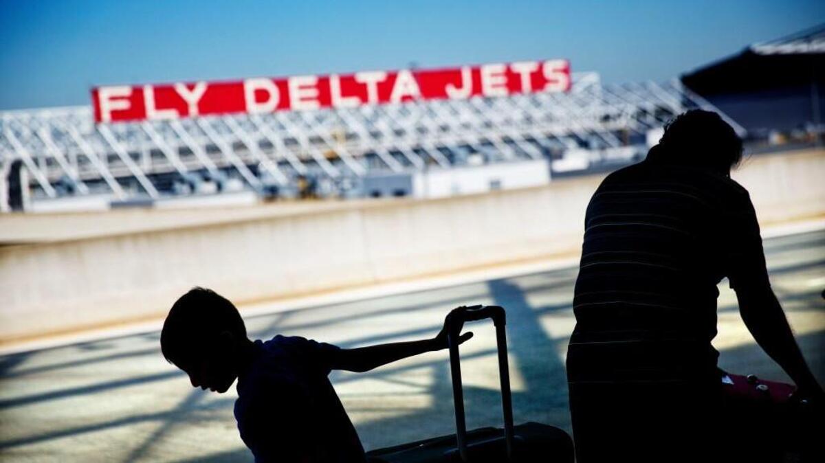 In this 2016 file photo passengers unload in front of a Delta Air Lines sign at Hartsfield-Jackson Atlanta International Airport, in Atlanta.