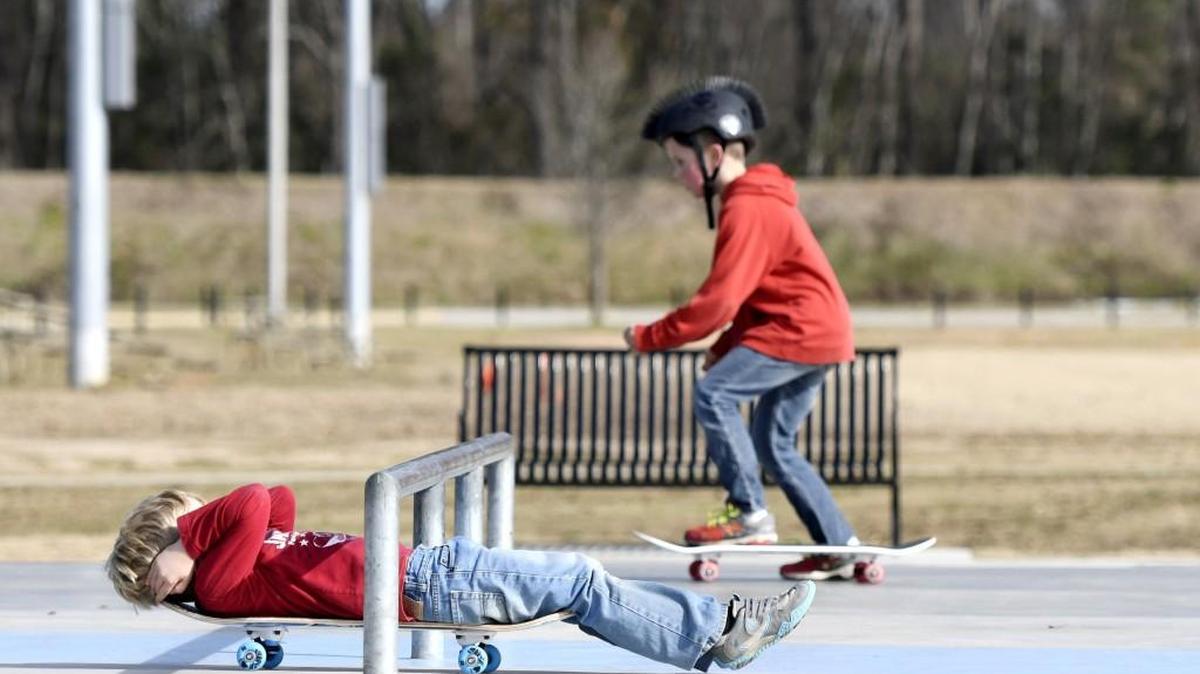 Ollie Hayes slides under a grind rail on his new skateboard while his older brother, Henry, rides his at the skatepark at Central City Park in this 2017 file photo.