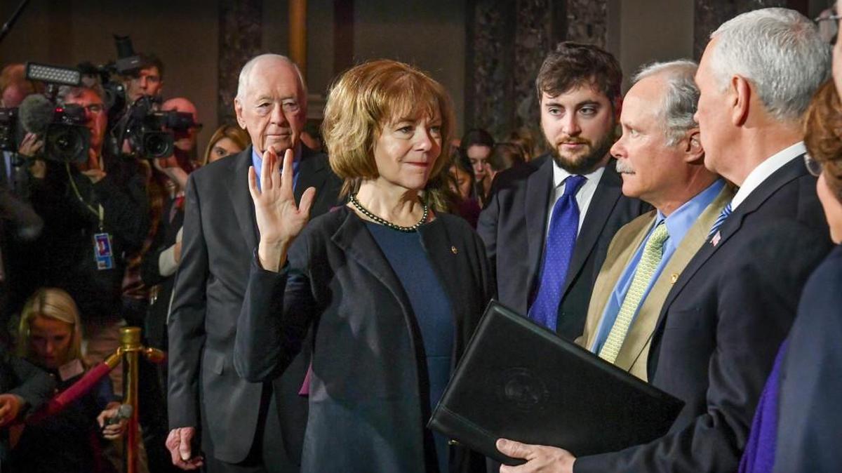 Vice President Mike Pence, right, administers the Senate oath of office during a mock swearing in ceremony in the Old Senate Chamber to Sen. Tina Smith, D-Minn., left, with her husband Archie Smith, second from right, Wednesday, Jan. 3, 2018 on Capitol Hill in Washington. Sen. Smith will take over from Al Franken who resigned.