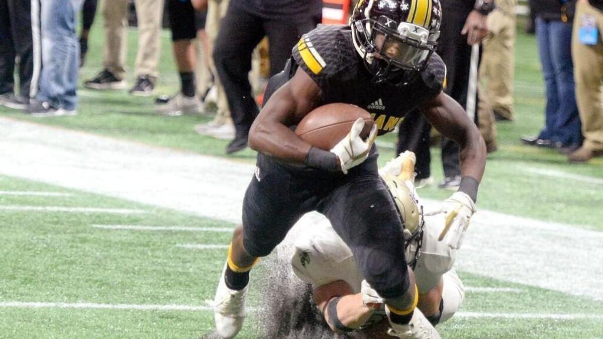 Peach County receiver Noah Whittington (35) heads for the end zone after a fourth quarter reception against Calhoun in their GHSA State Championship game in Atlanta on Friday. An official called the catch incomplete and the Trojans eventually lost 10-6.