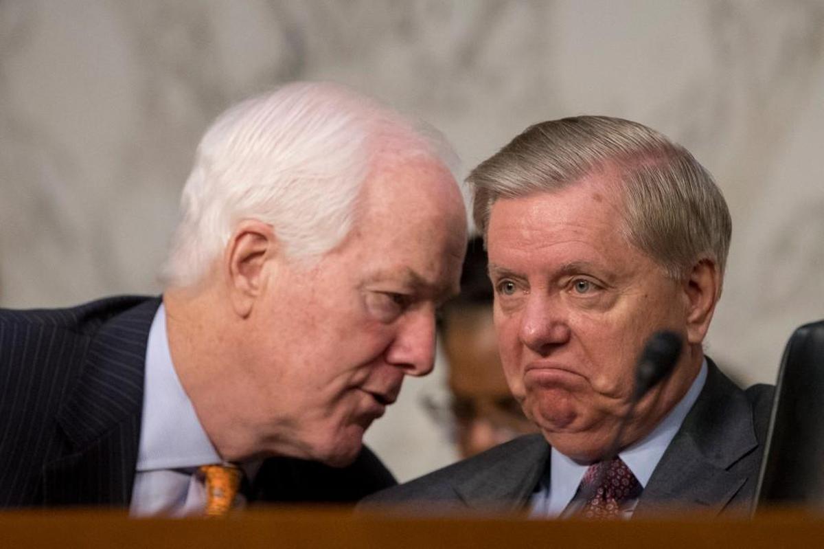 Senate Majority Whip Sen. John Cornyn, R-Texas., left, speaks with Sen. Lindsey Graham, R-S.C., right, during a Senate Judiciary Committee hearing on Capitol Hill in Washington, Tuesday, Oct. 3, 2017, on the Trump Administration's decision to end Deferred Action for Childhood Arrivals otherwise known as DACA.