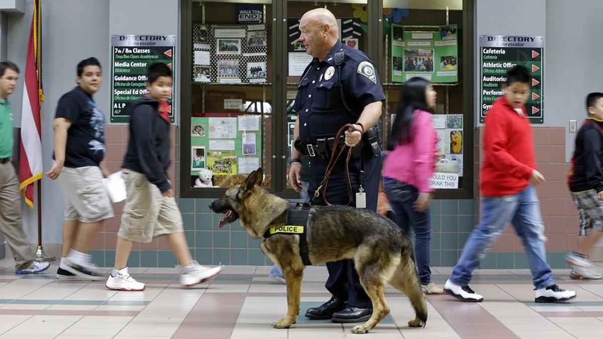 An officer and his dog walk the halls at a school in Indianapolis.