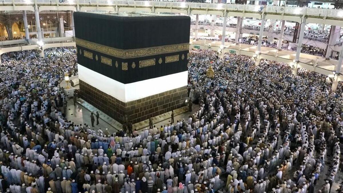 The pilgrims are doing tawaf around the kaabah by walking counter-clockwise seven times. The pilgrims were standing to start praying.