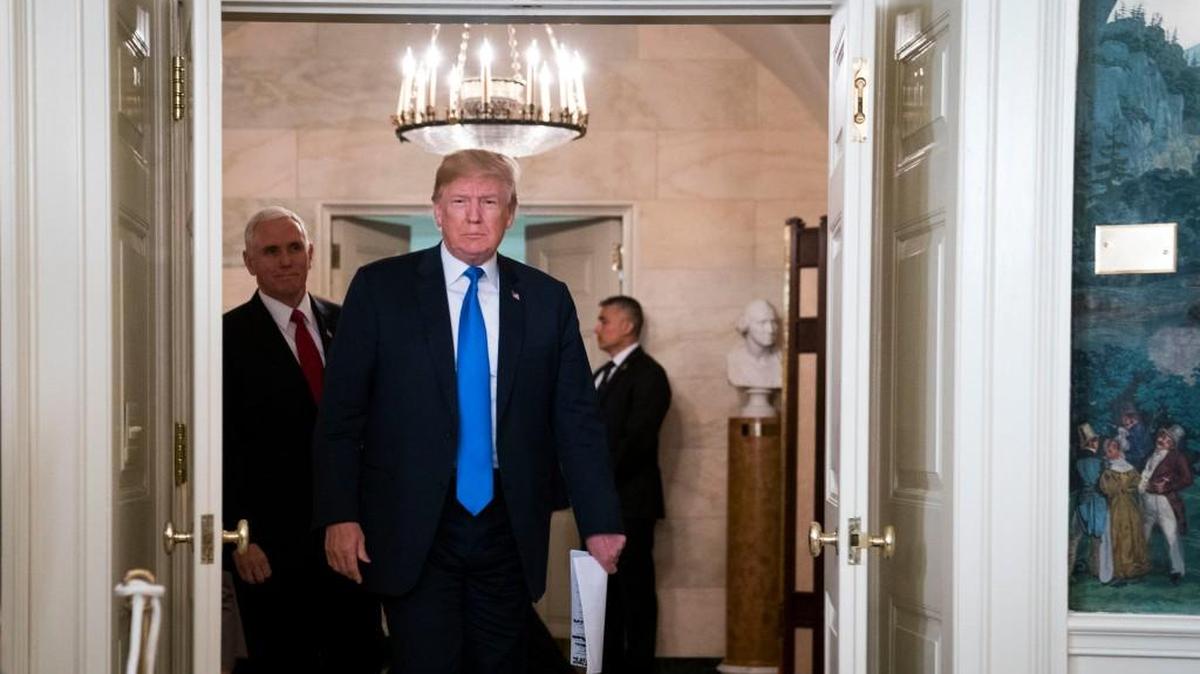 President Donald Trump is trailed by Vice President Mike Pence as he walks through the White House in Washington, D.C., on Thursday.