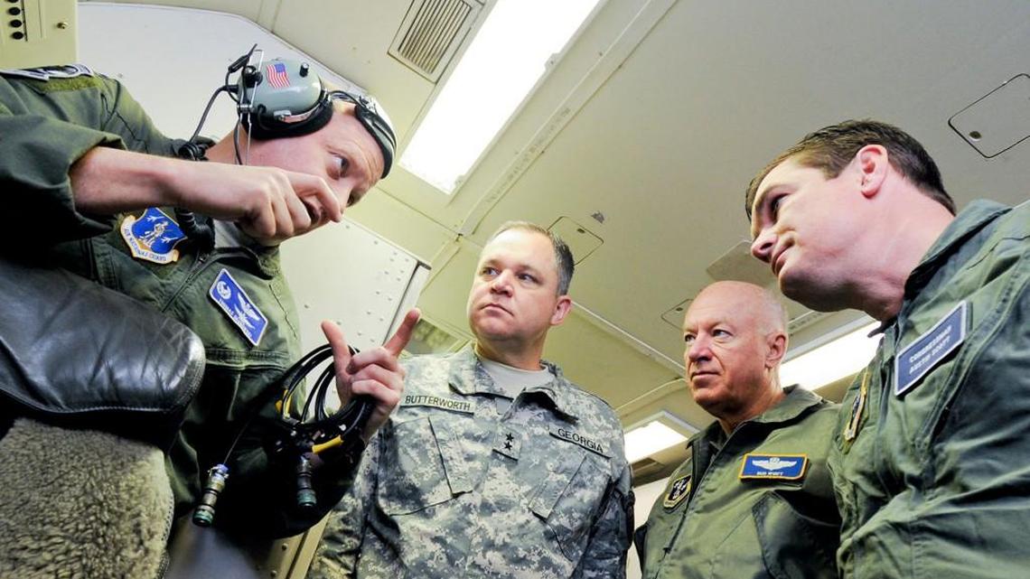 Air National Guard Lt. Col. Thomas Grabowski, left, 116th Operations Support Squadron commander, briefs Maj. Gen. Jim Butterworth, Adjutant General of Georgia, Lt. Gen. Harry Wyatt III, guard director, and Rep. Austin Scott, on the mission and capabilities of the E-8 Joint STARS during an orientation flight aboard one of the planes at Robins Air Force Base in 2011.