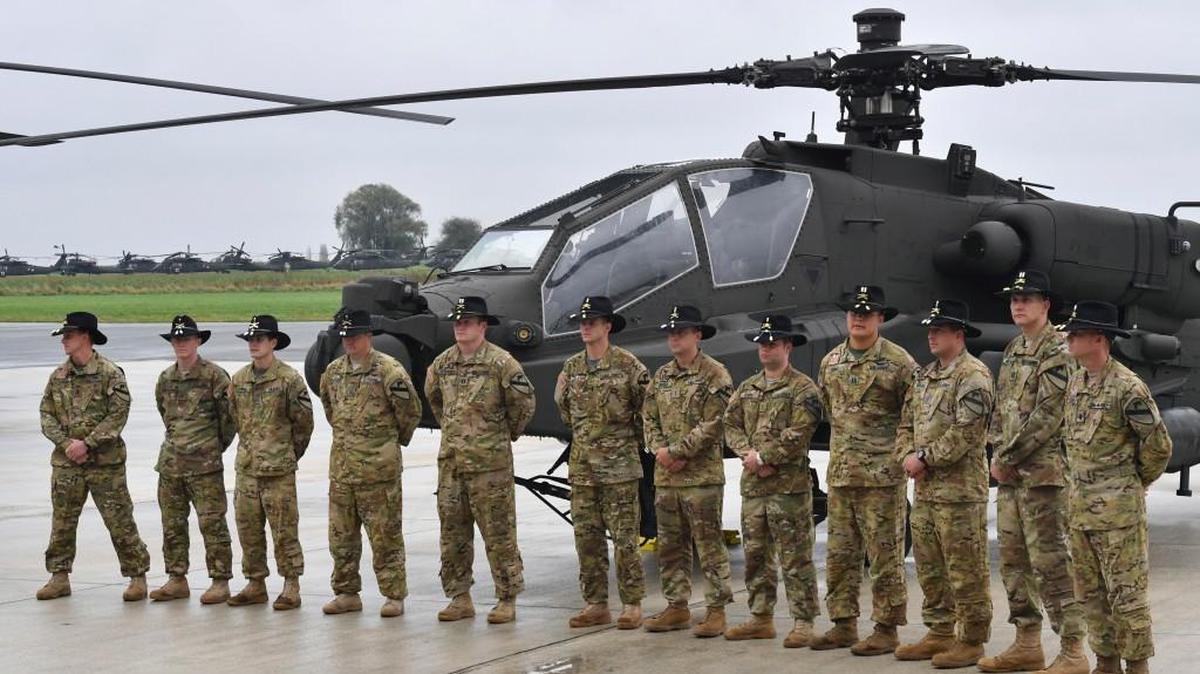 Soldiers from the US Army 1st Cavalry Brigade, 1st Cavalry Division, stand in front of helicopters on the tarmac at Chievres Air Base in Chievres, Belgium, Tuesday, Oct. 24, 2017. The 1st Cavalry Brigade made a refueling stop at the base in Belgium on it's way to a nine-month rotation in Illesheim, Germany to support Operation Atlantic Resolve and other training missions across Europe.