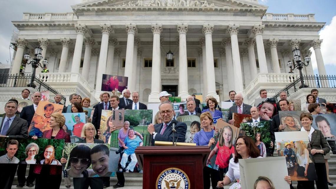 Senate Minority Leader Sen. Chuck Schumer of N.Y. and his fellow Democratic Senators, hold photographs of constituents who would be adversely affected by the proposed Republican Senate healthcare bill during a news conference outside the Capitol Building in Washington, Tuesday, June 27, 2017.