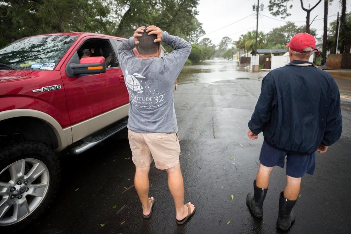 Joey Spalding, center, reacts to looking at the street where he live, Monday, Sept., 11, 2017, on Tybee Island, Ga. Spalding just finished repairing his house from nine inches of water after Hurricane Matthew past the island last year. He said the Tropical Storm Irma brought three feet of storm surge into his living room today.