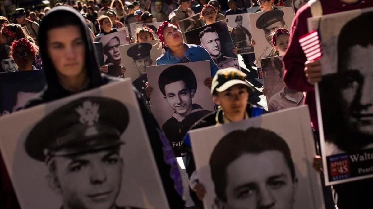 People carry photos of soldiers who died during the attack on Pearl Harbor.