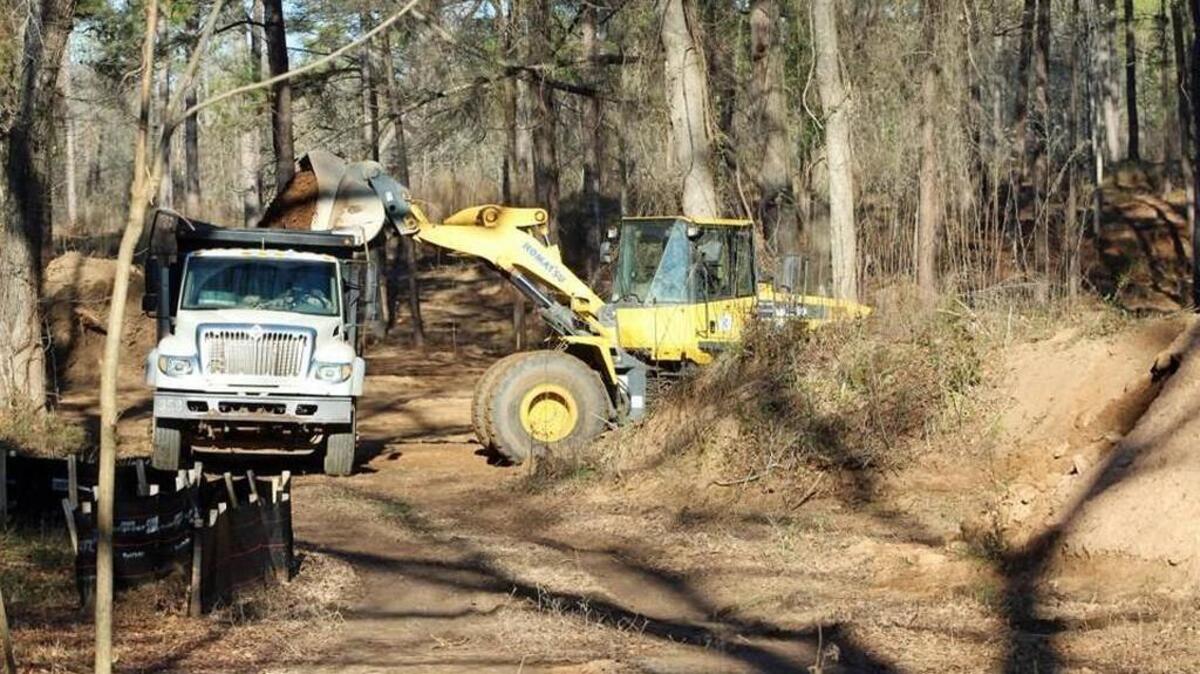A Houston County work crew moves dirt from a site at Wellston Park in Warner Robins that is slated to become a dog park.
