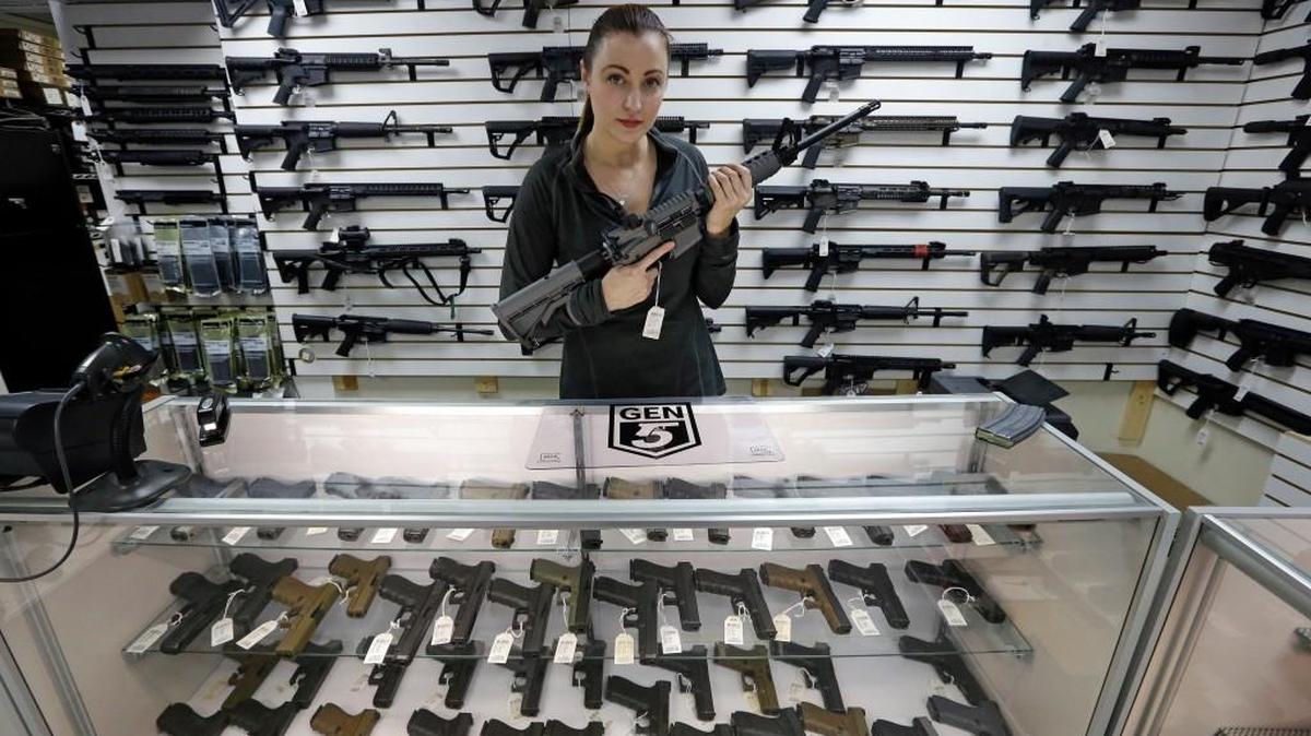 Gun shop owner Tiffany Teasdale-Causer poses for a photo with a Ruger AR-15 semi-automatic rifle, the same model, though in gray rather than black, used by the shooter in a Texas church massacre two days earlier, Tuesday, Nov. 7, 2017, in Lynnwood, Wash. Gun-rights supporters have seized on the Texas church massacre as proof of the well-worn saying that the best answer to a bad guy with a gun is a good guy with a gun. Gun-control advocates, meanwhile, say the tragedy shows once more that it is too easy to get a weapon in the U.S.