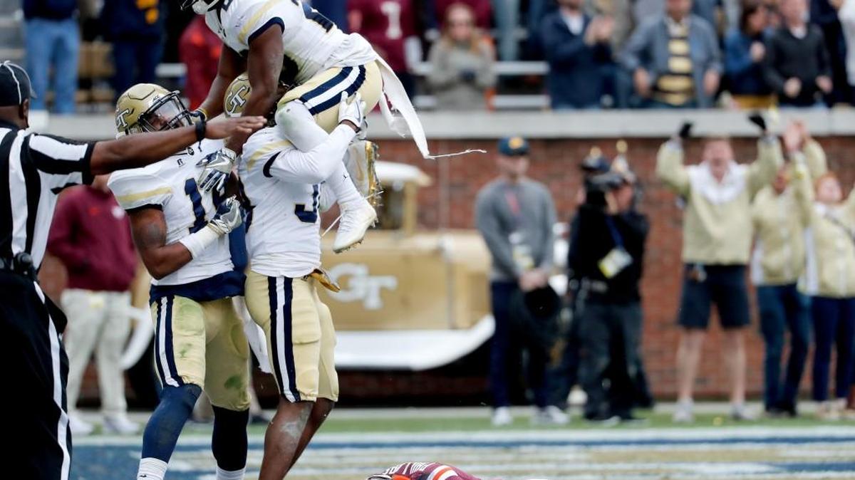 Virginia Tech's Cam Phillips lies on the field as Georgia Tech's Ajani Kerr, center left, celebrates with teammates Corey Griffin, left, and Lawrence Austin after Kerr broke up a pass intended for Phillips in the end zone late in the fourth quarter of Saturday’s game.