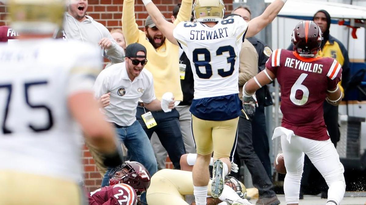Georgia Tech's Ricky Jeune, bottom right, scores a touchdown against Virginia Tech's Terrell Edmunds as teammate Brad Stewart and fans celebrate in the fourth quarter of an NCAA college football game in Atlanta, Saturday, Nov. 11, 2017. Georgia Tech beat Virginia Tech 28-22.