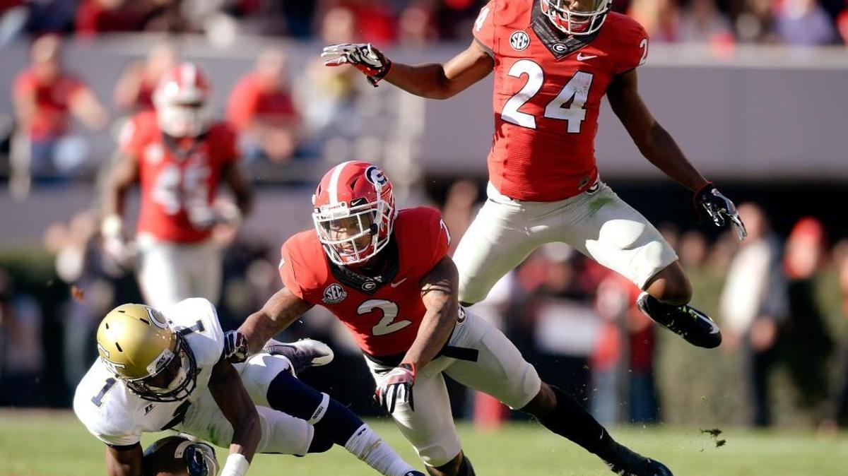 Georgia Tech’s Qua Searcy (1) is knocked to the ground by Georgia’s Maurice Smith (2) after hauling in a deep pass during their game Saturday.