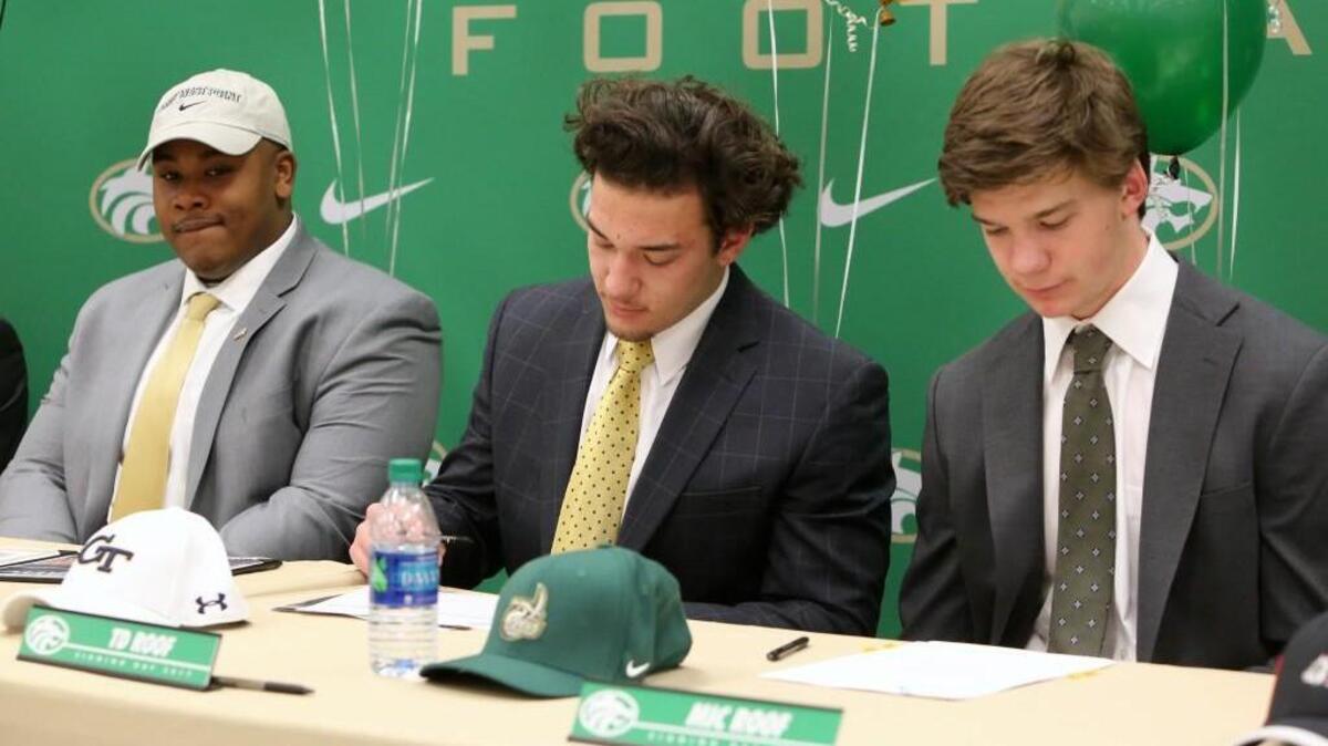 Buford's Dean Powell (L) and brother Mic Roof (R) flank T.D. Roof as he signs his letter-of-intent to Georgia Tech.