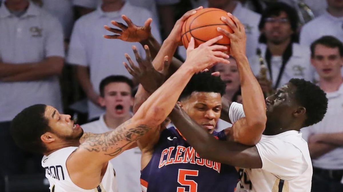 Georgia Tech defenders Josh Heath, left, and Abdoulaye Gueye force a turnover on a double-team against Clemson's Jaron Blossomgame during the Yellow Jackets’ victory Thursday.