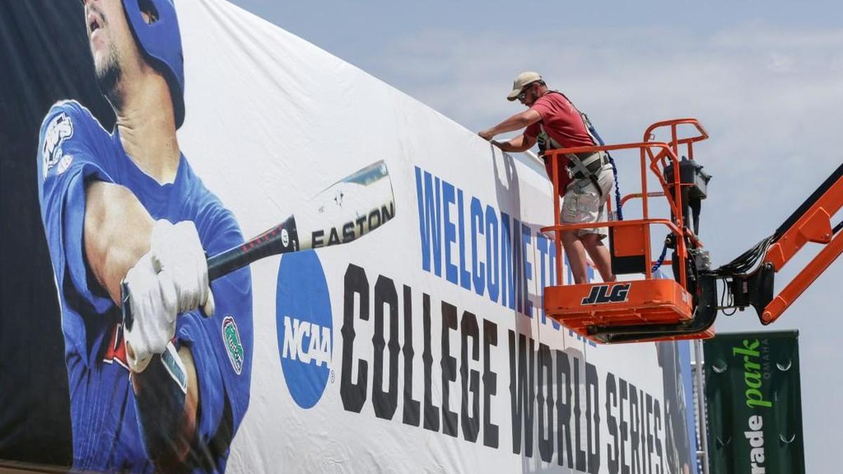 Bryan Hartley, an employee of Sport Graphics in Indianapolis, works on a large banner welcoming fans to the College World Series, Thursday in Omaha, Neb. Preparations for the NCAA College World Series Baseball tournament continue at TD Ameritrade Park in Omaha.