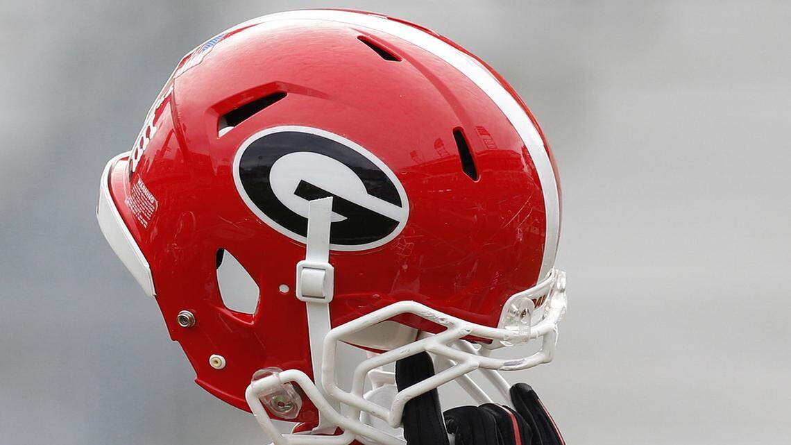A Georgia helmet is held in the air. 