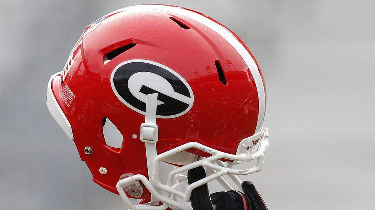 A Georgia helmet is held in the air. 