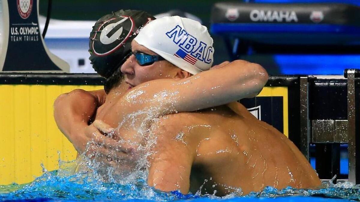 Chase Kalisz (right) gets a hug from Jay Litherland (left) after the 400-meter individual medley final at the U.S. Olympic swimming trials. Kalisz won and Litherland finished second.