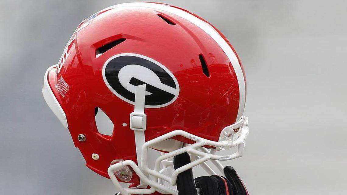 A Georgia helmet is held in the air.