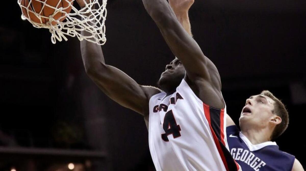 Georgia's Derek Ogbeide, left, gets past George Washington's Tyler Cavanaugh to dunk the ball during the second half of Monday’s game.