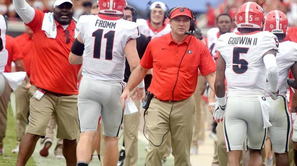 Georgia head coach Kirby Smart on the sideline as Jake Fromm and Terry Godwin move past him.