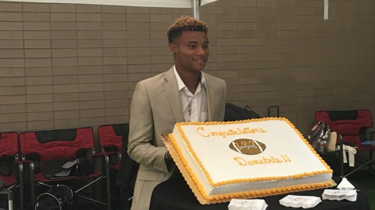 Demetris Robertson poses for a photo with a celebratory cake his family made for him.