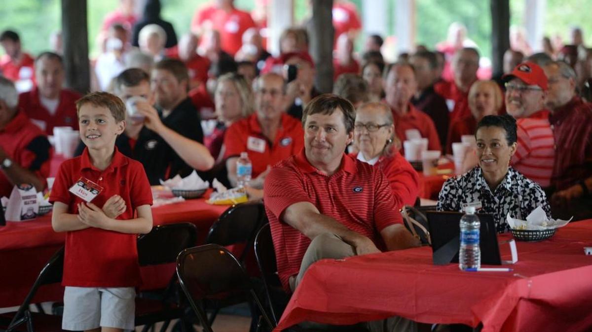 Wes Stewart stands next to Georgia football Kirby Smart during a barbecue for Bulldogs fans Wednesday at the Walnut Creek Shooting Preserve Wednesday.
