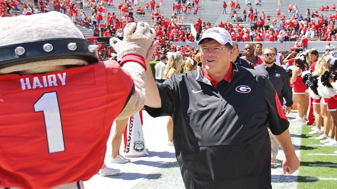 Jim Chaney high-fives Hairy Dawg. 