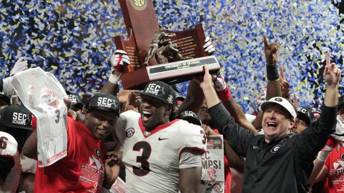 Roquan Smith and head coach Kirby Smart celebrate the SEC Championship trophy after the Bulldogs beat Auburn 28-7 to take the SEC Championship at Mercedes Benz Stadium in Atlanta.