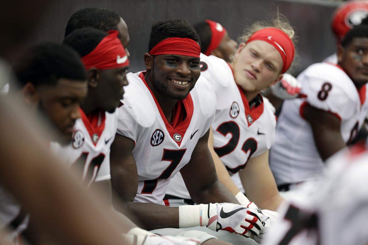 Lorenzo Carter, seen sitting with his teammates during the Georgia-Tennessee game, is one to smile a lot, as this photo shows. 