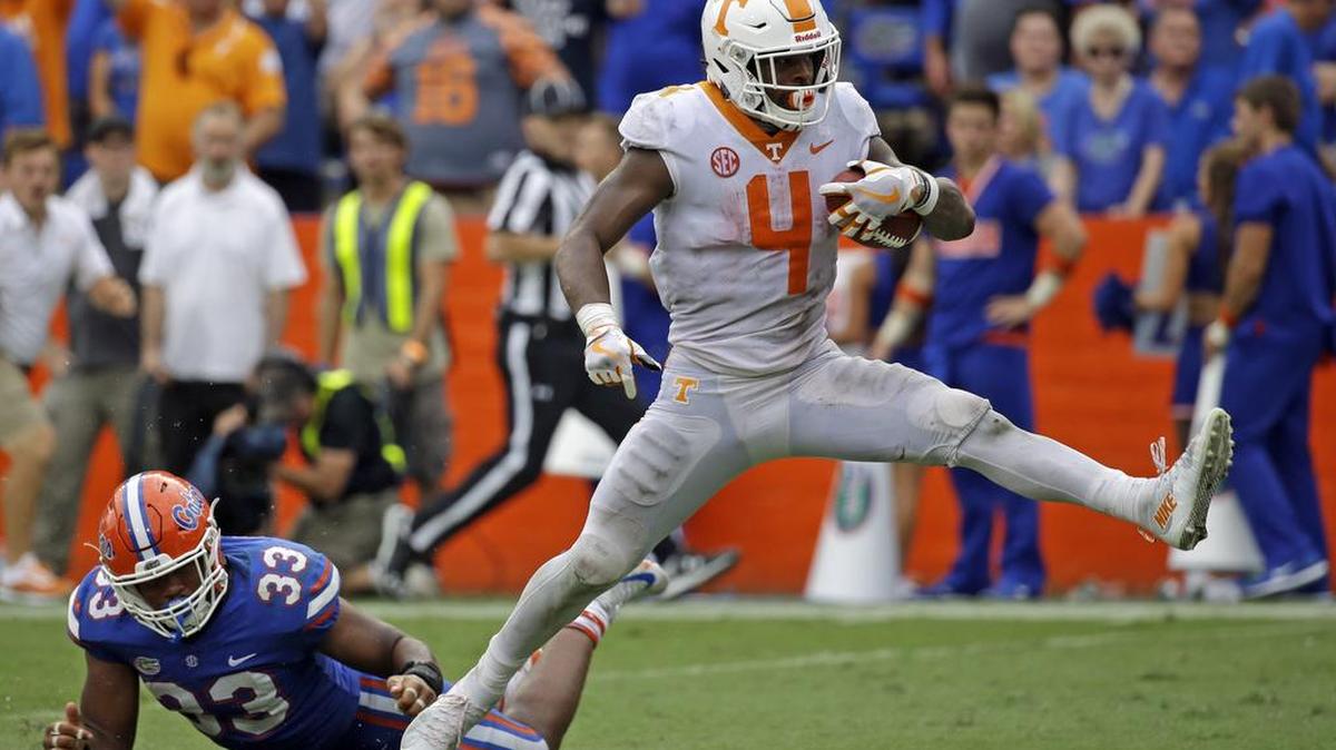 Tennessee running back John Kelly (4) scores a touchdown past Florida linebacker David Reese (33) on a 34-yard run.