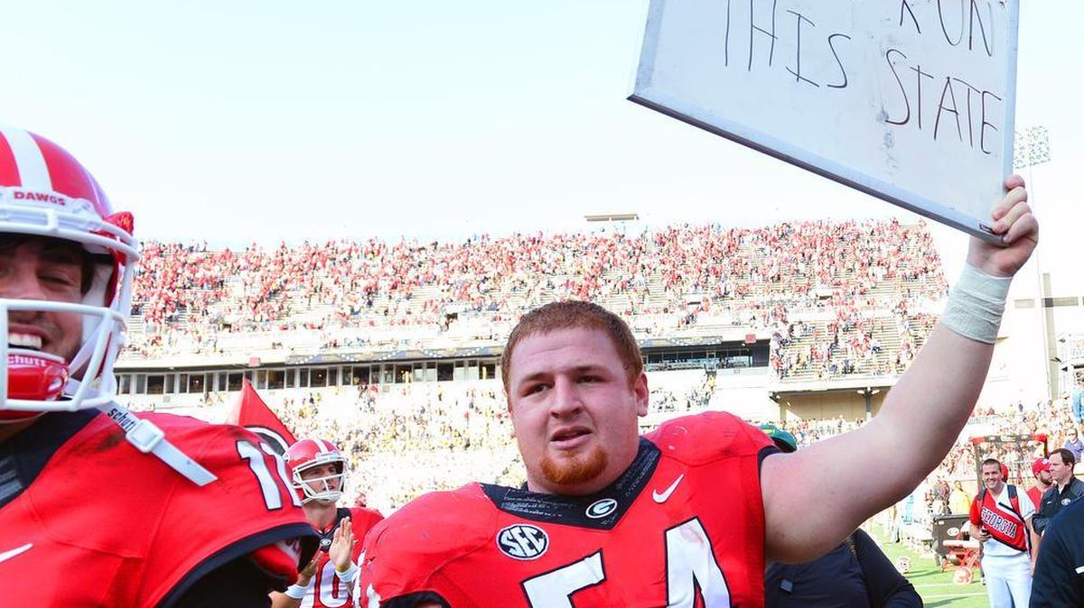 Georgia offensive lineman Brandon Kublanow (54) holds a sign that reads, “We run this state,” after the Bulldogs beat Georgia Tech in 2015.