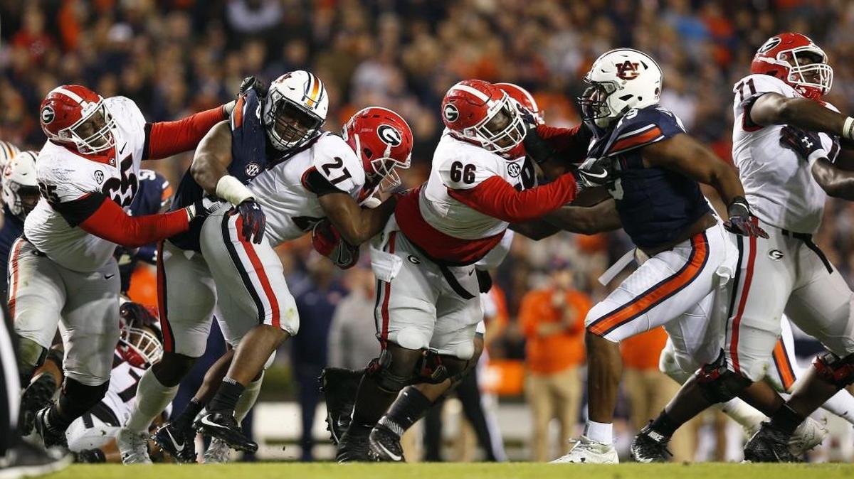 Auburn’s Dontavius Russell, second from left, tackles Georgia’s Nick Chubb (27) during their first game this season. Auburn’s defense shut down the Bulldogs running game, holding Chubb to 27 yards on 11 carries. Georgia finished the game gaining only 46 rushing yards.