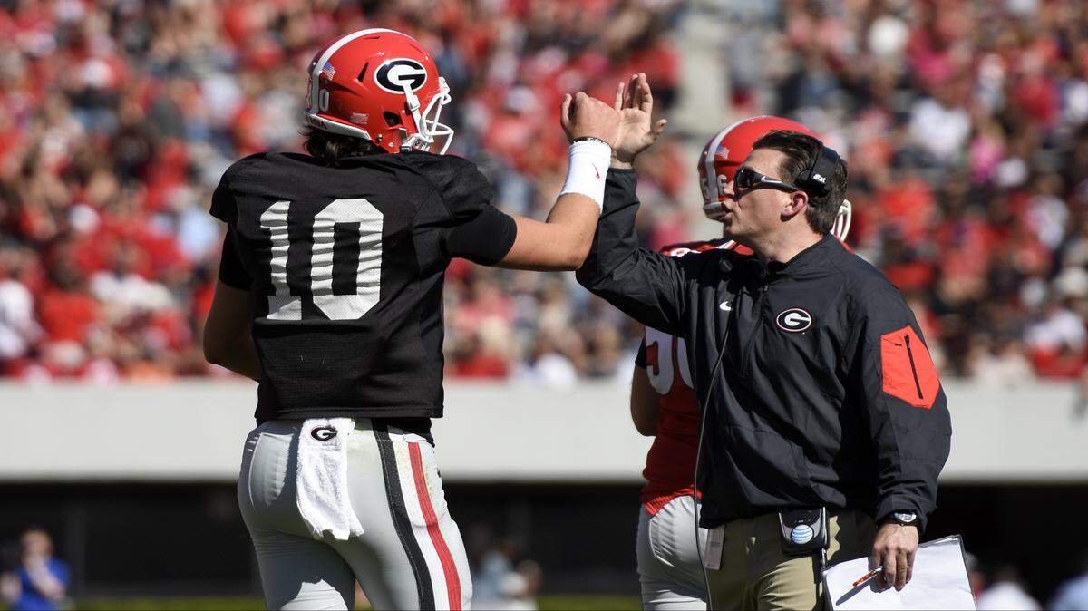 Georgia receivers coach James Coley gives quarterback Jacob Eason a high five. 
