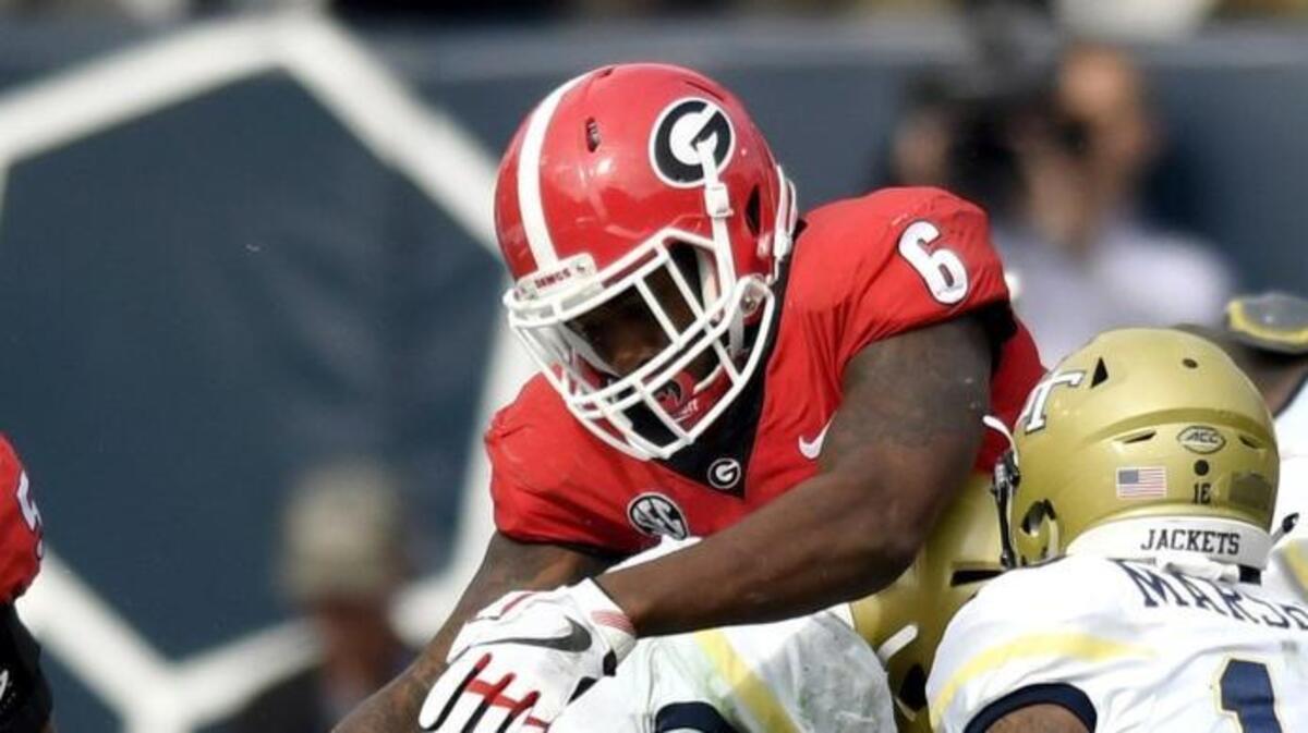 Georgia linebacker D'Andre Walker (15) tackles Georgia Tech b-back KirVonte Benson (30) at the line of scrimmage.