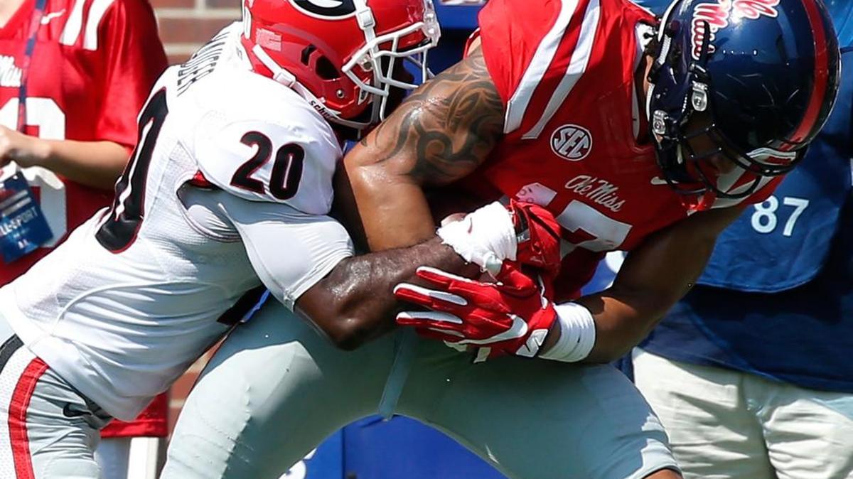 Mississippi tight end Evan Engram (17) fights for more yards as Georgia safety Quincy Mauger (20) tries to tackle him.