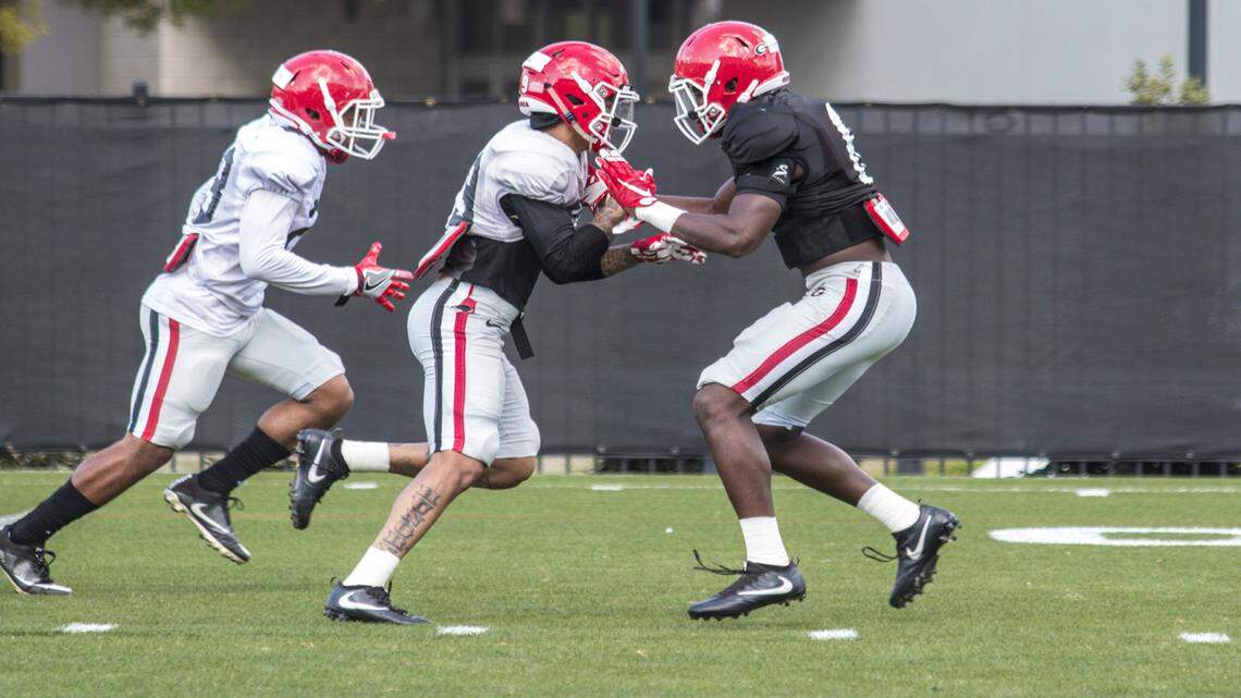 Deangelo Gibbs (right) goes through a drill during spring practice. 