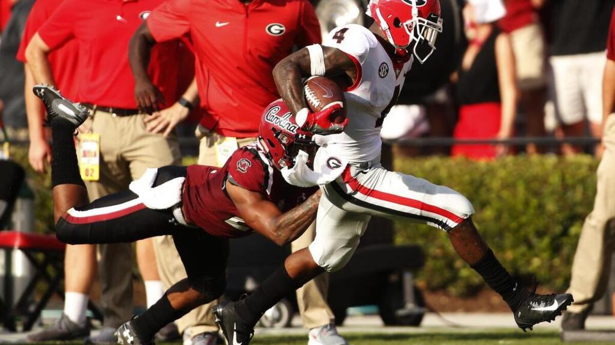 Georgia wide receiver Mecole Hardman (4) breaks a tackle from South Carolina defensive back Steven Montac (22) during the second half of their game Saturday in Columbia, S.C.